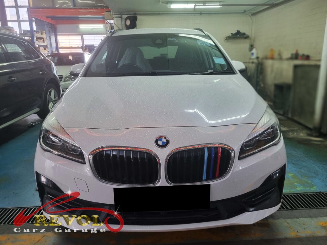 BMW 216i with the front of the engine open for timing cover repair.