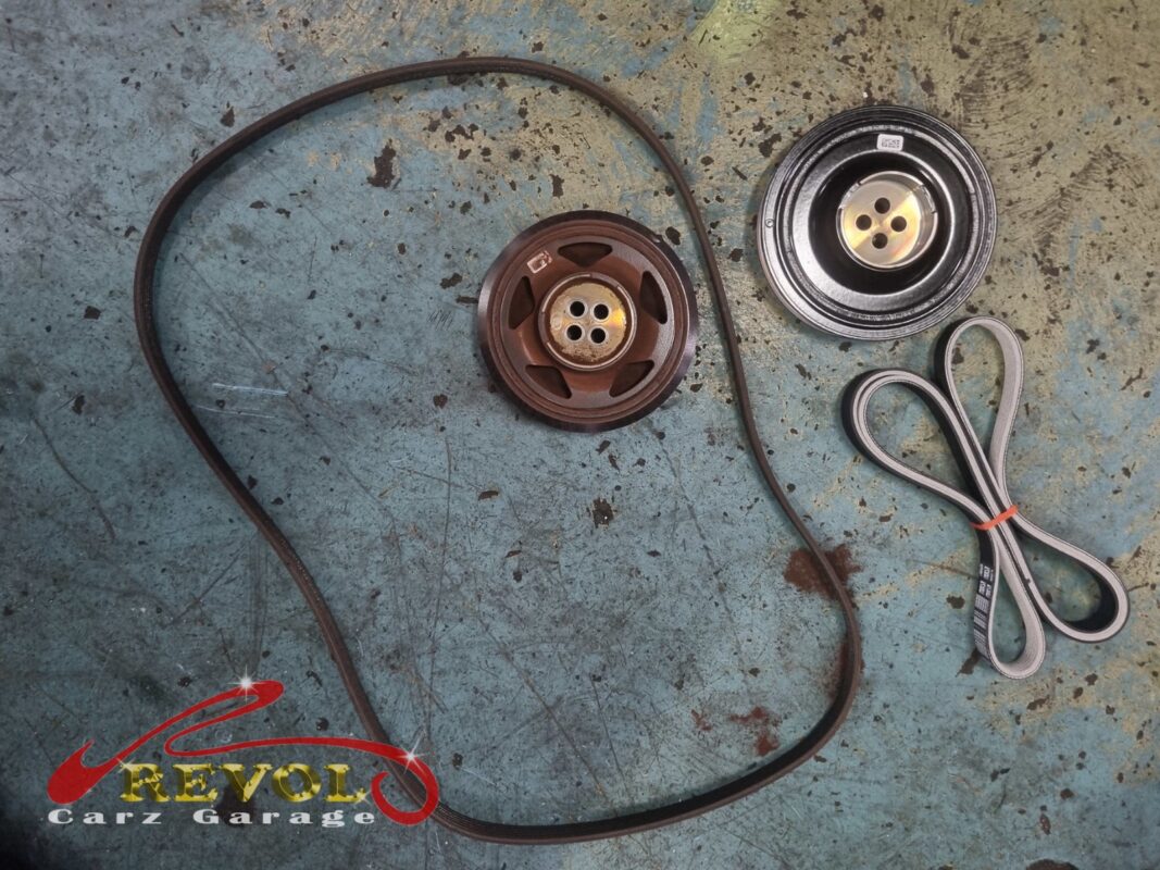 The old belt and crankshaft pulley (left) beside the new BMW-spec belt and pulley (right).