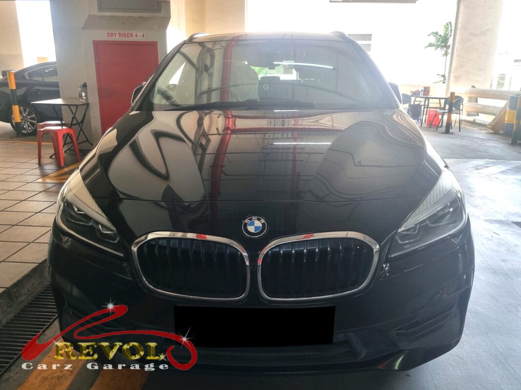 BMW 216i with the engine bay open for thermostat housing replacement.