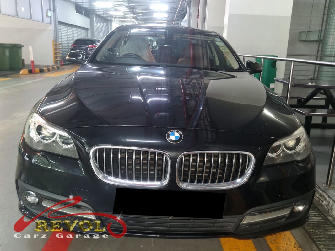 BMW 520i with the engine bay open for alternator pulley replacement.