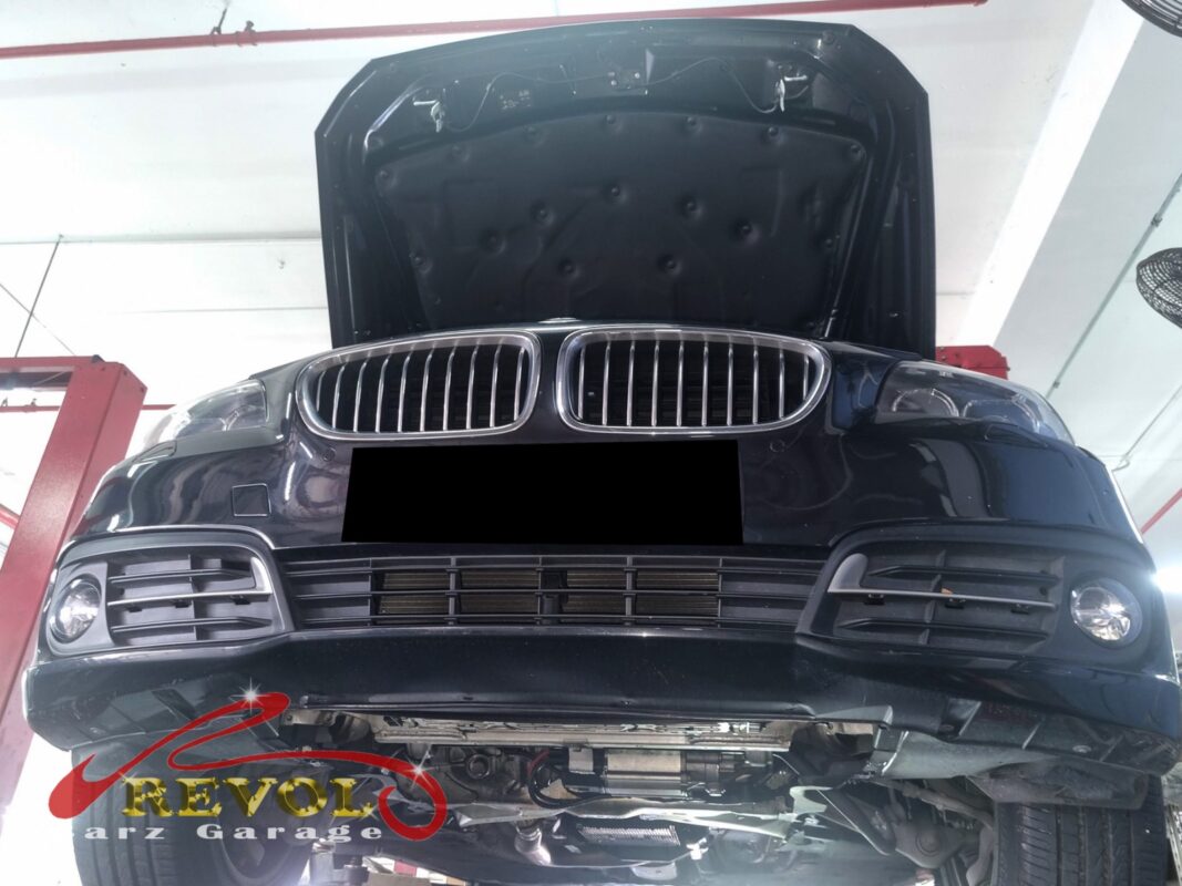 The 520i up on the two-post lift, in for the hard-start complaint.