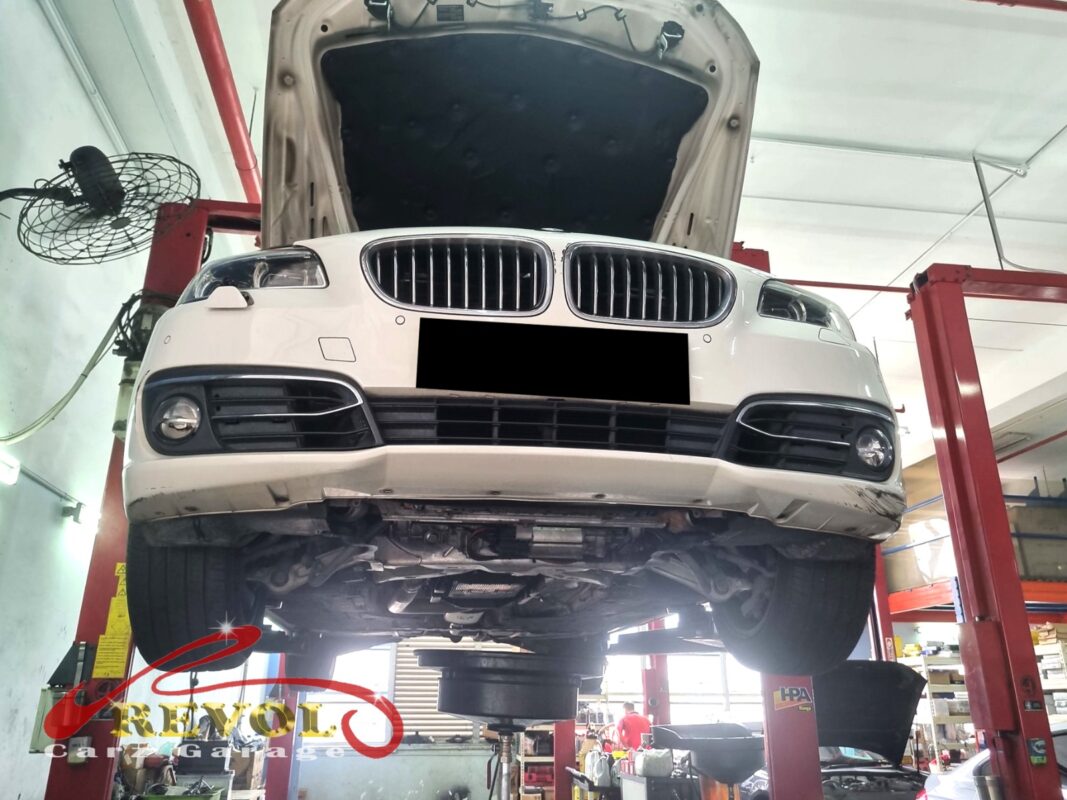 The 520i up on the two-post lift, in for the front struts.