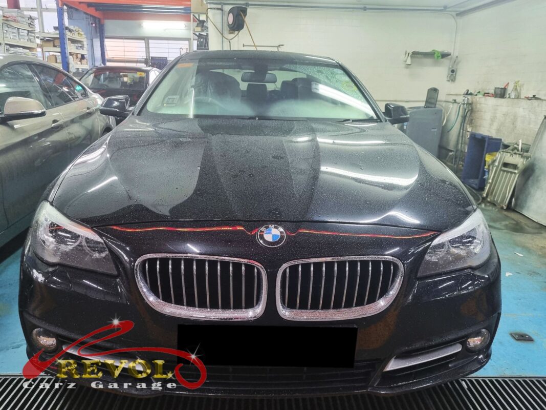 BMW 520i with the engine bay open for oil filter housing inspection.