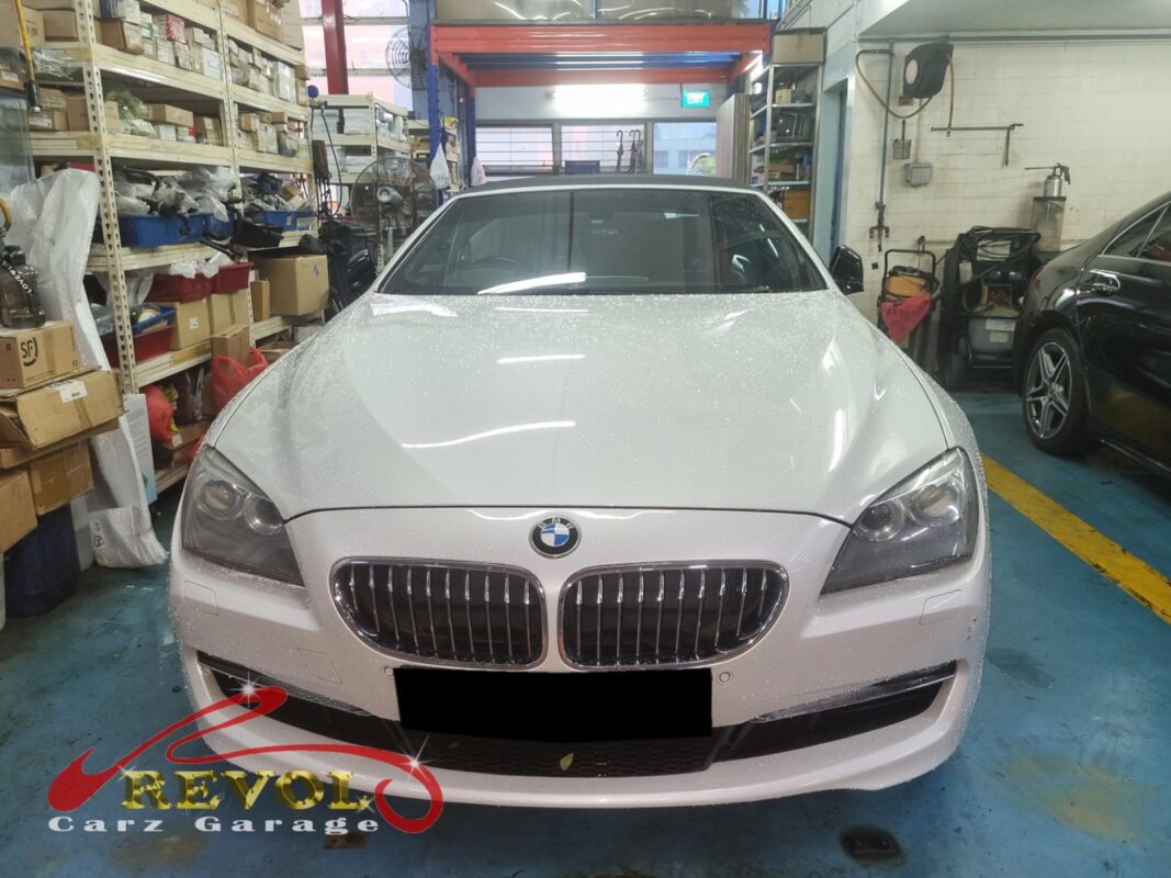 BMW 640i with the engine cover off for ignition coil replacement across all six cylinders.