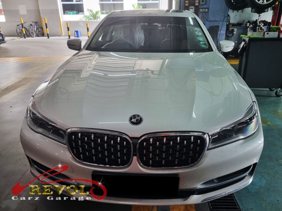BMW 730Li on the workshop lift with the front wheel off for bearing inspection.