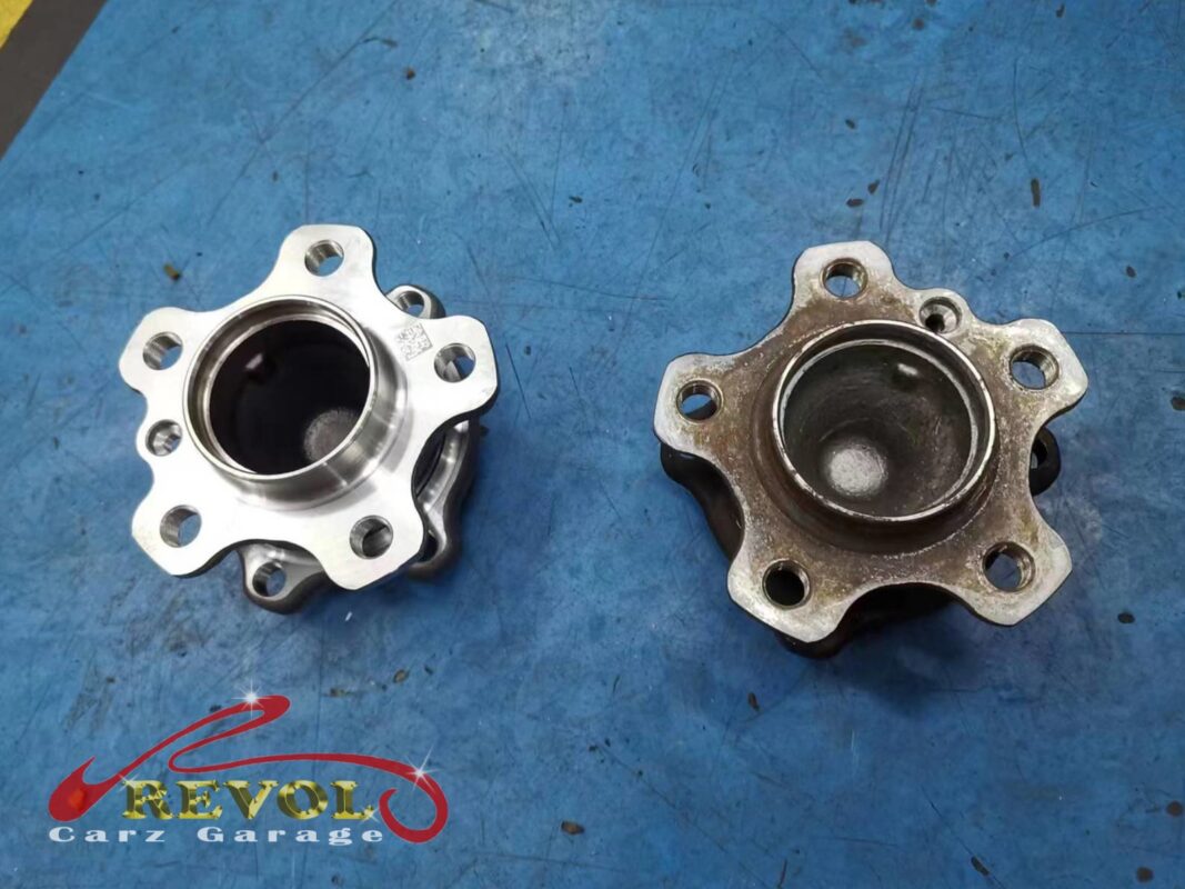 The old front wheel hub and bearing (right, rusted) beside the new BMW-spec unit (left).