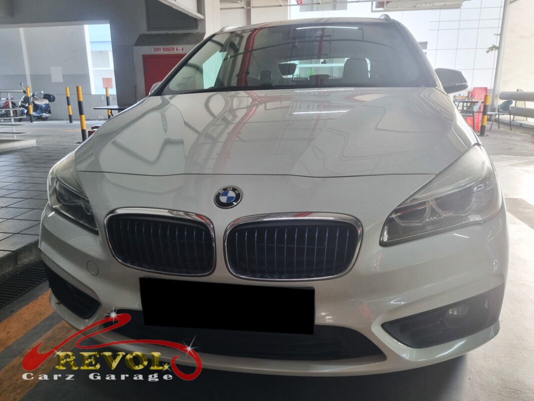 BMW 225xe with the front of the engine exposed for timing cover repair.