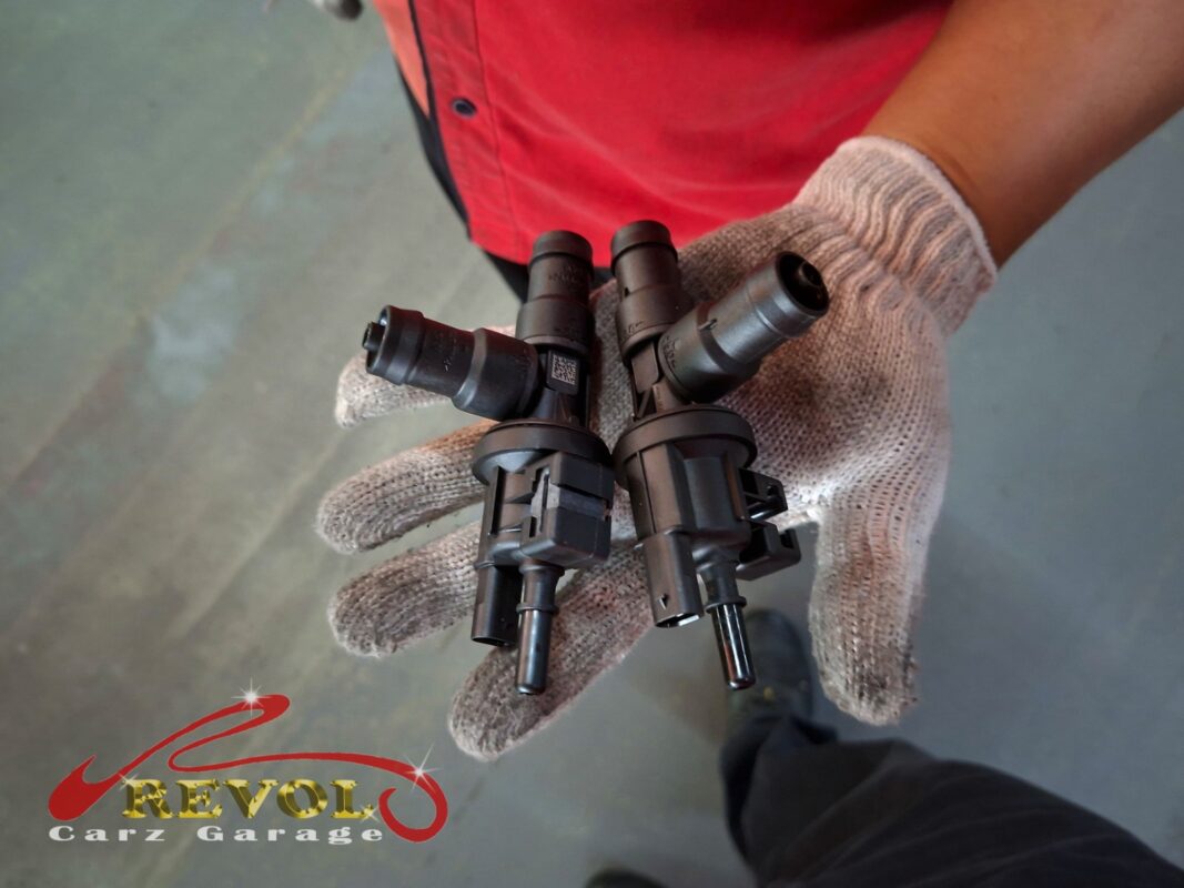 The old EVAP purge valve beside the new BMW-spec replacement.