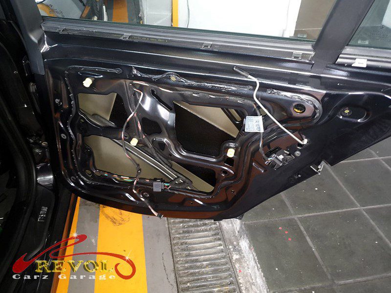 The failed window regulator with cracked plastic and the cable off its track.
