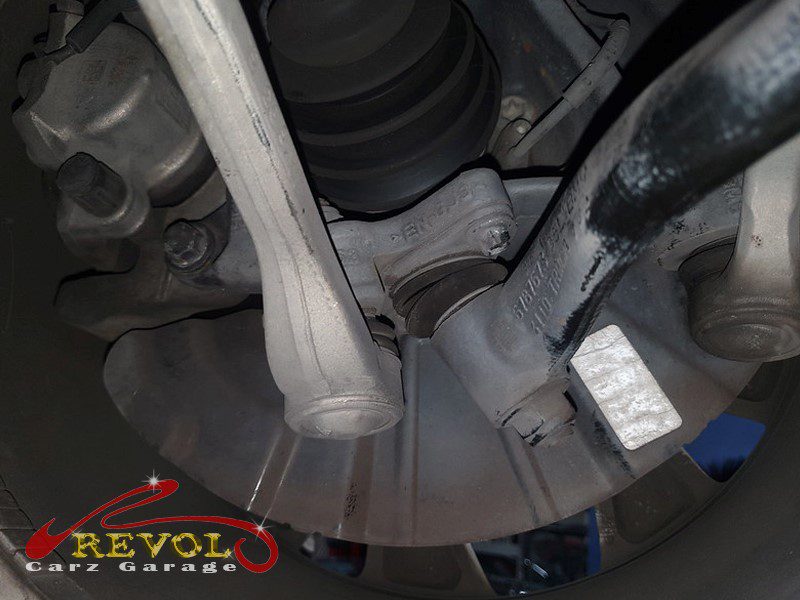 The worn front control arm bush with cracked, separating rubber.