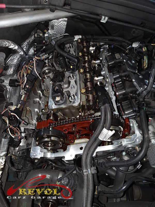 The old warped plastic valve cover removed from the cylinder head.