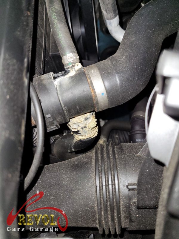 The old cracked coolant expansion tank removed from the engine bay.