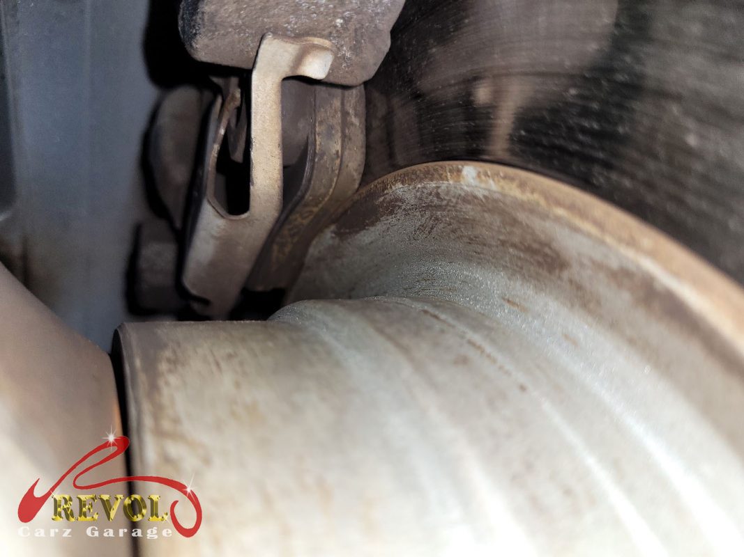 The old rear discs removed alongside the new genuine set.