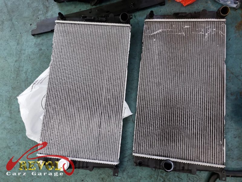The old cracked radiator removed from the front of the car.