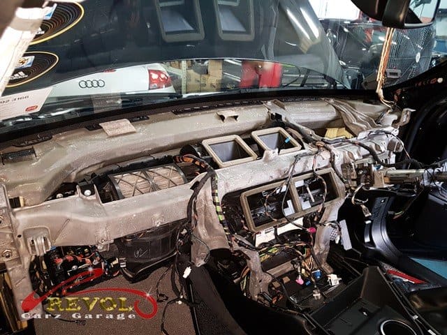 The dashboard being dismantled to reach the cooling coil behind it.