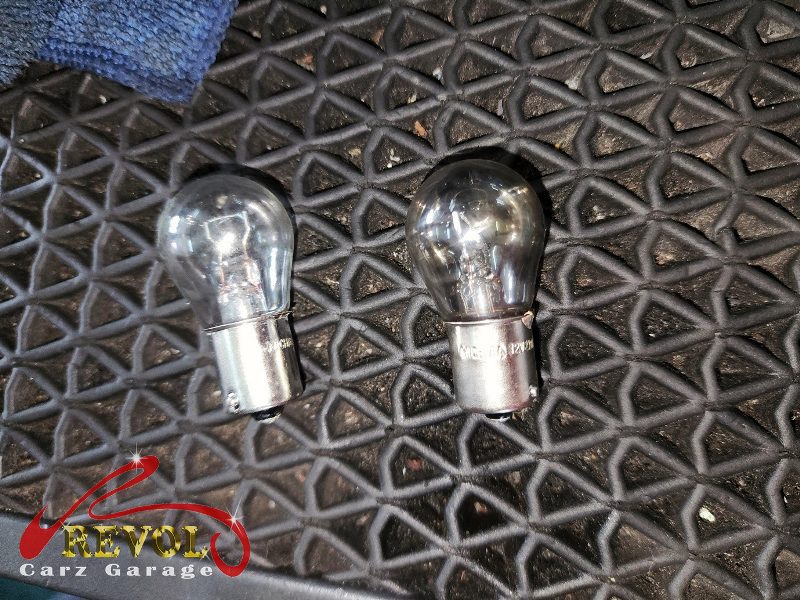 The dead brake light bulb removed from its holder.