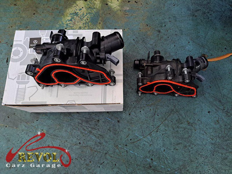 The old cracked plastic thermostat module removed from the engine.
