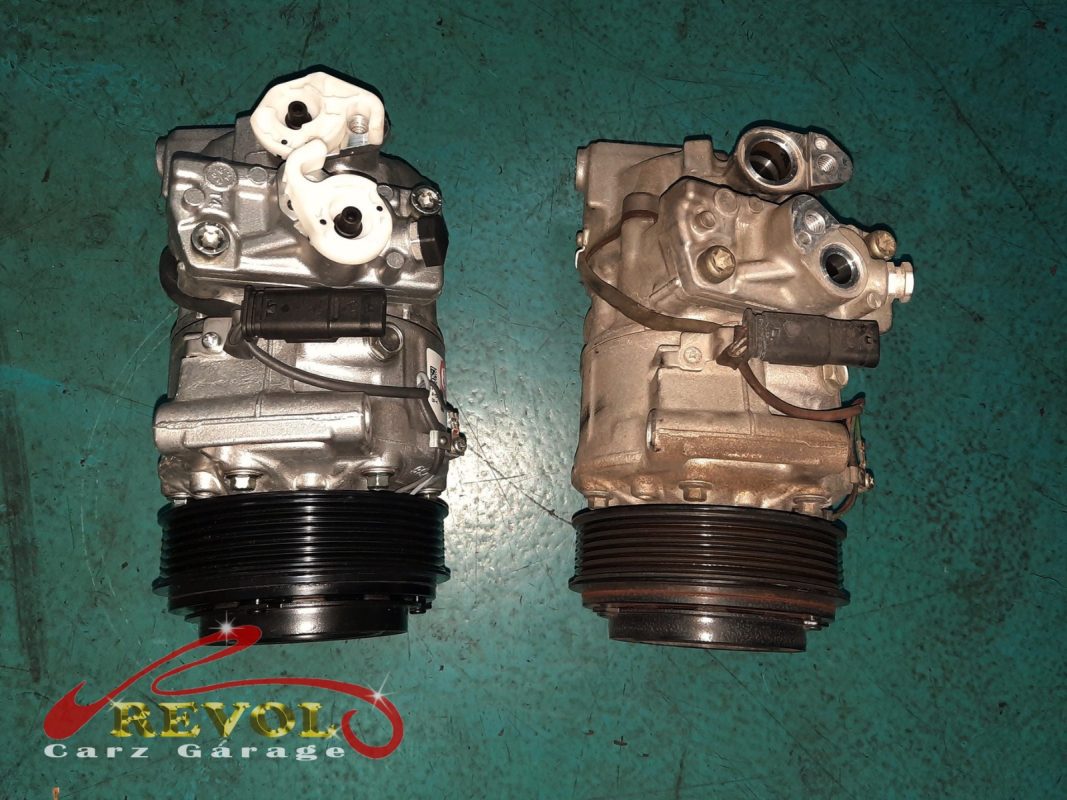 The old failed aircon compressor removed alongside the new compressor and receiver-drier.
