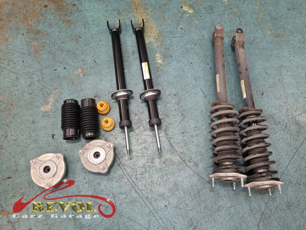 The old shocks removed beside the new Mercedes-spec set.