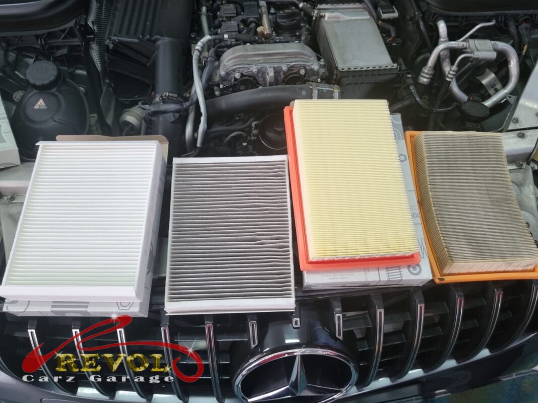 The old air filter beside the new Mercedes-spec replacement.