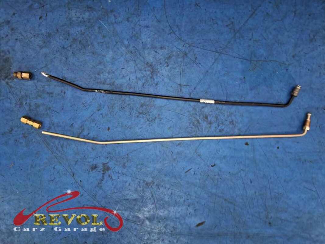The old brake line section (top) beside the new replacement (bottom), with new union fittings.