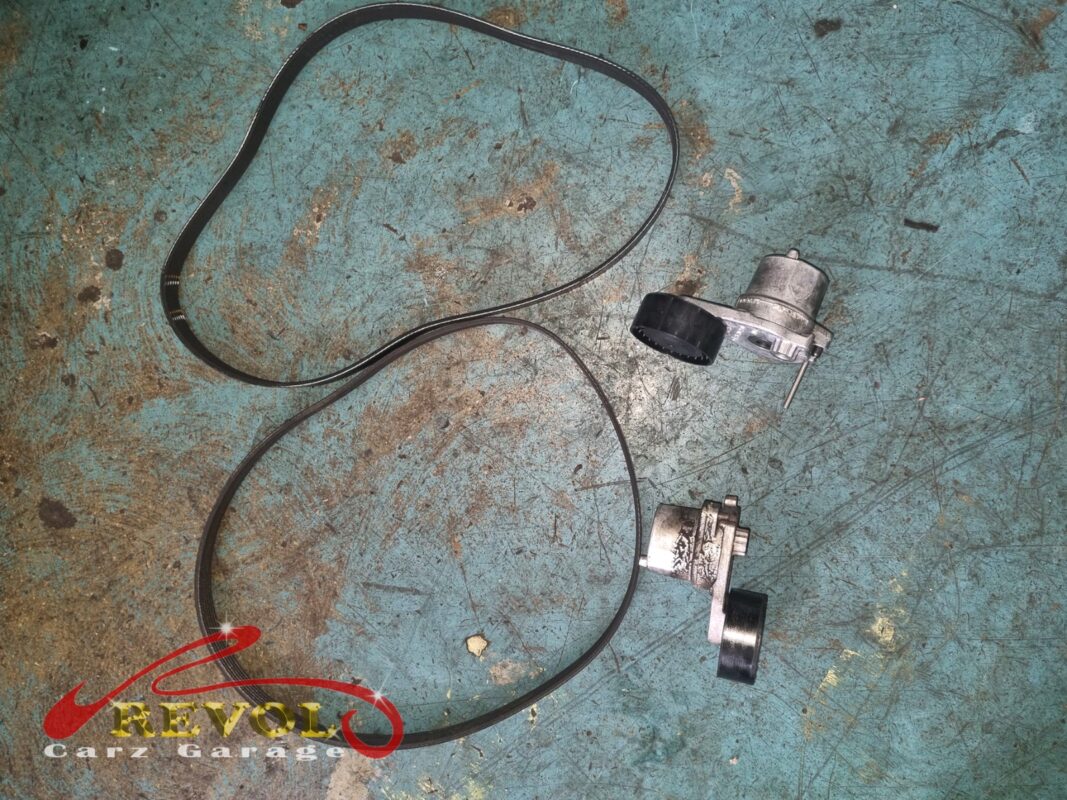 The old accessory belt and tensioner (top) beside the new Mercedes-spec tensioner (bottom).