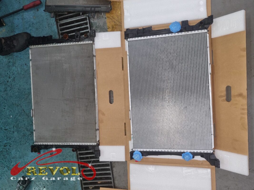 The old radiator (left, grimy) beside the new Mercedes-spec replacement (right).
