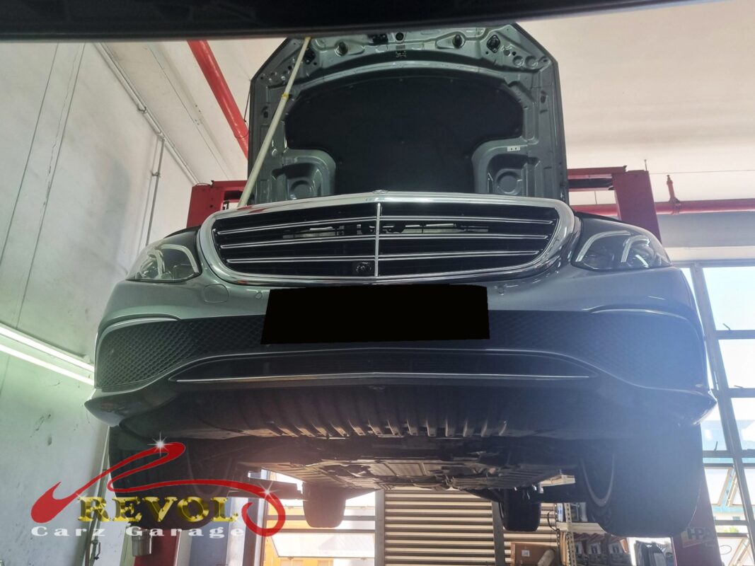 The E250 up on the two-post lift, in for the cold-start squeal.