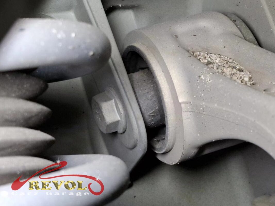 Close-up of an old upper-arm bush in the arm eye, the rubber tired and the casting around it corroding.