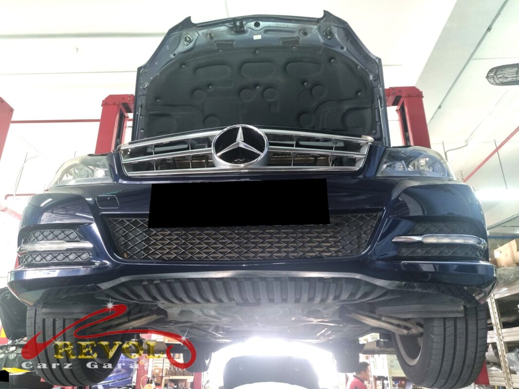 The C180 up on the two-post lift, hood open, in for the bouncy rear end.