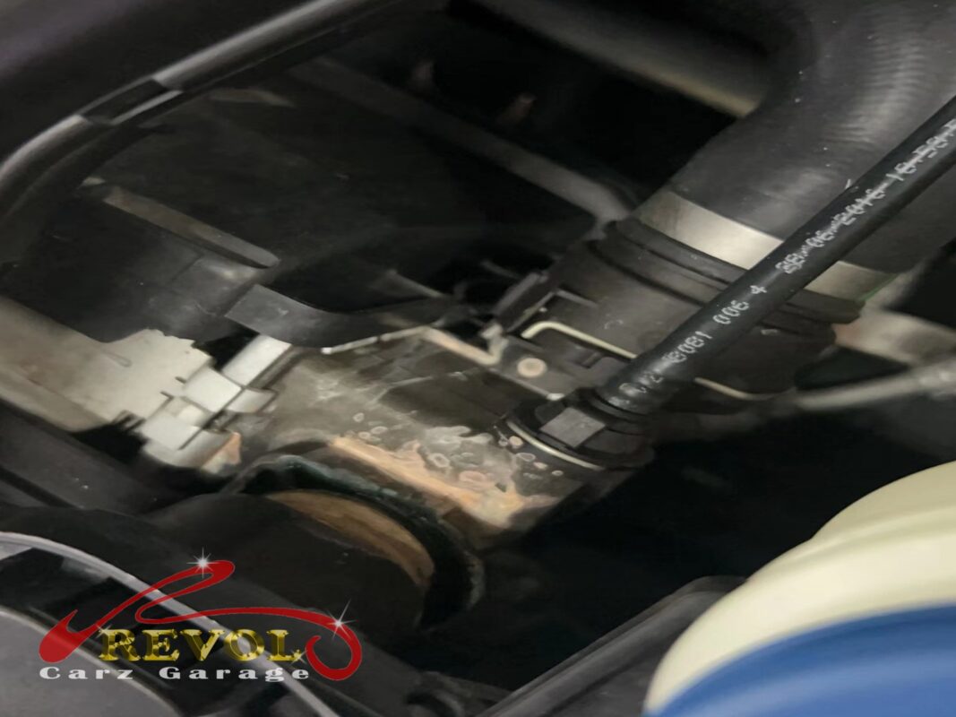 Dried coolant residue around a cooling-system joint in the engine bay, the trace of the leak.