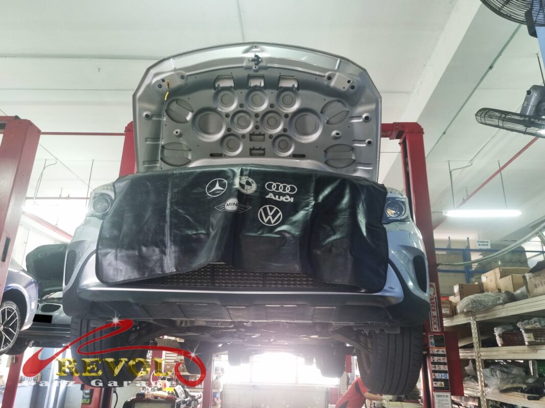 The C180 up on the two-post lift, fender cover on, in for its scheduled service.