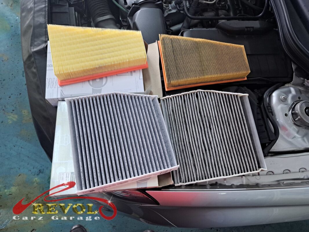Old and new filters side by side: the engine air filter (top) and the cabin filter (bottom), each swapped for a fresh one.