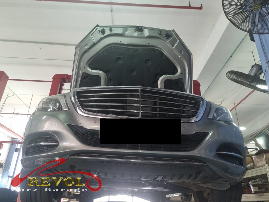 The S400L up on the two-post lift, hood open, in for the coolant leak.