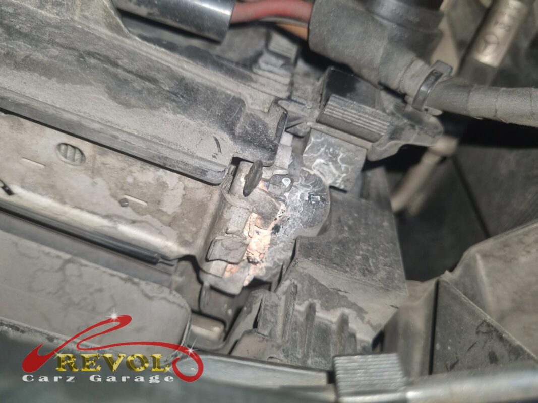 Dried coolant and corrosion crust at the front of the engine bay, the trace of the cracked radiator.