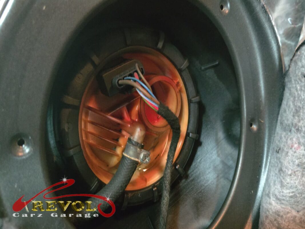 The in-tank fuel pump and filter module exposed through the access hatch under the rear seat.