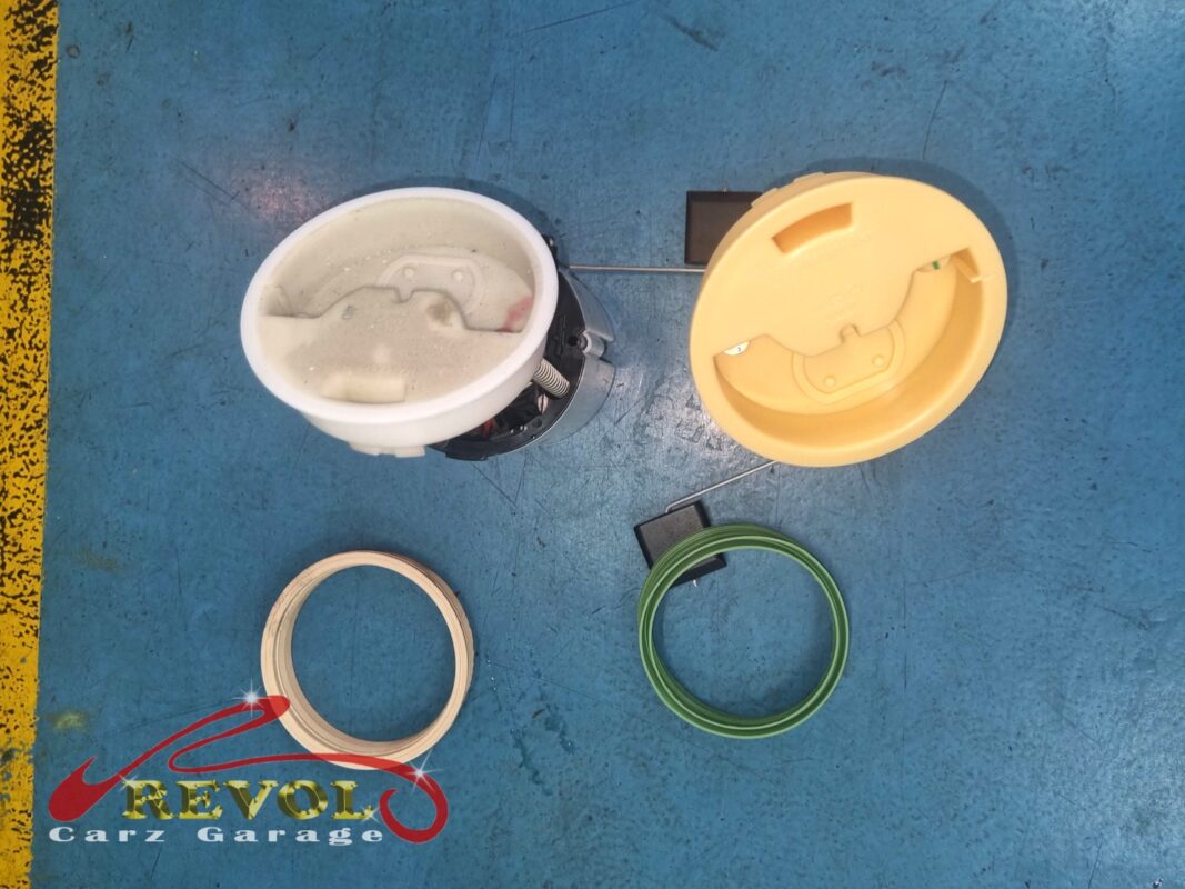 The old module's tank flange (left, fuel-stained) beside the new one (right), with fresh sealing rings.
