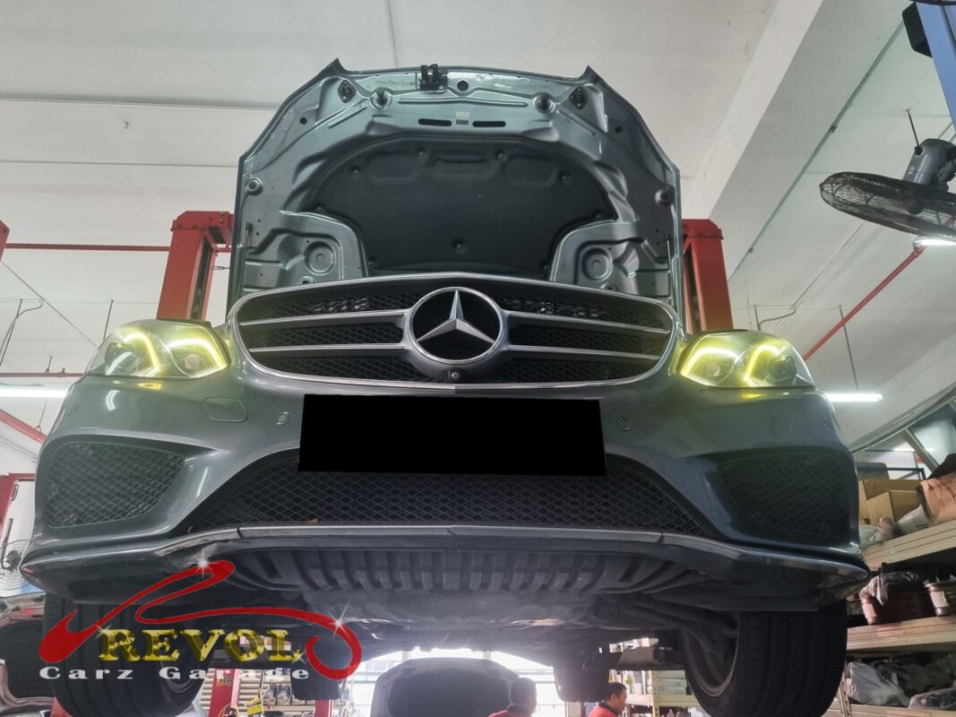 The E200 up on the two-post lift, hood open, in for the slow coolant loss.
