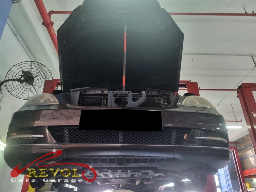 The car up on the two-post lift, hood open, in to track down the loose steering.