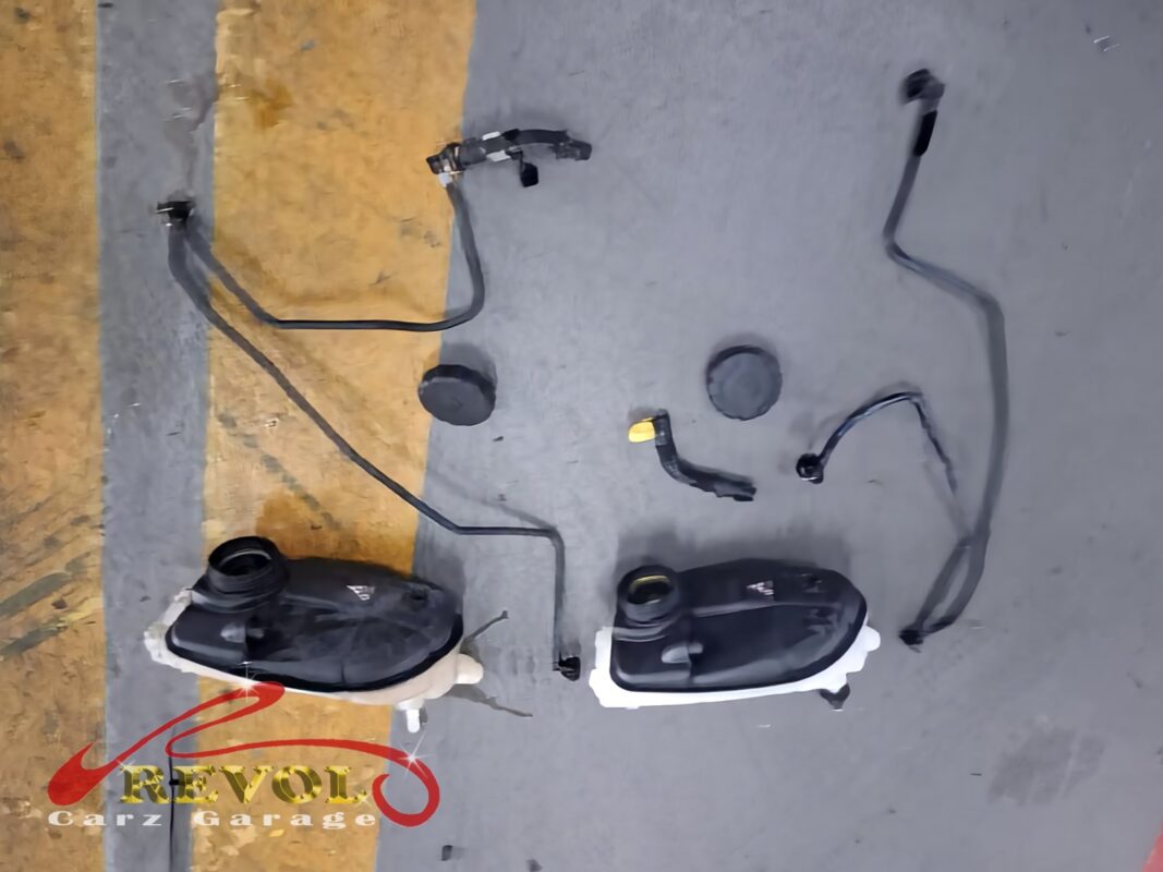 The old expansion tank, hose and cap (left) beside the new Mercedes-spec set (right).