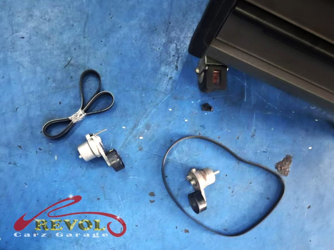 The old fan belt and tensioner (right) beside the new Mercedes-spec belt and tensioner (left).