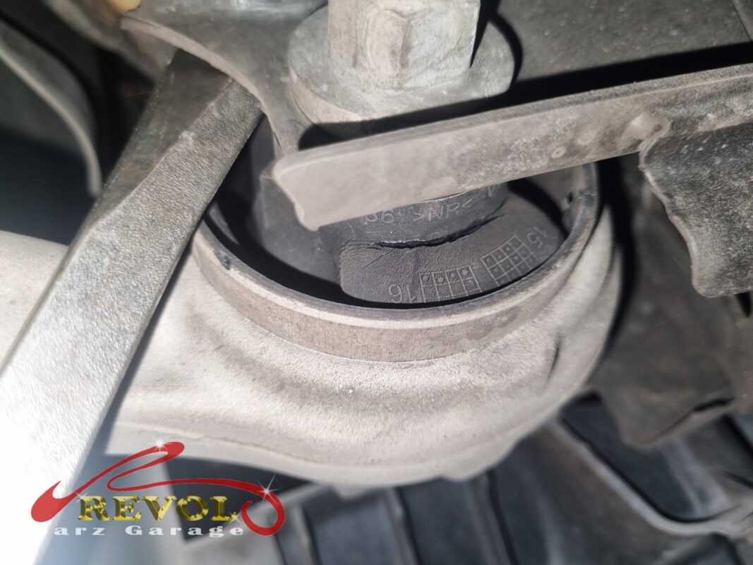An old lower-arm bush split through, the rubber cracked across it.