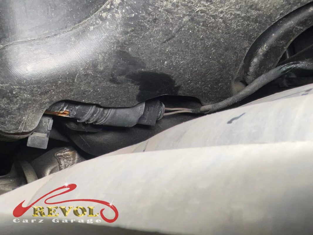 The washer pump's connection under the bonnet, corrosion building at the contact.