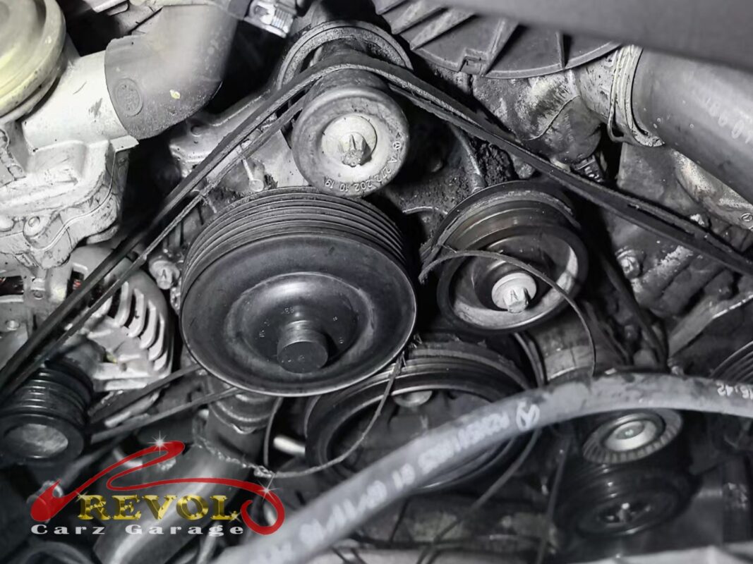 The accessory belt drive at the front of the engine, the belt looped over the pulleys before it came off.