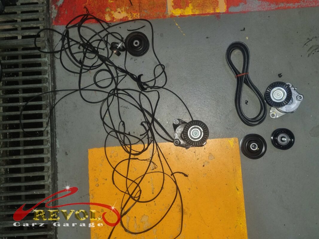 The old serpentine belt and tensioner (left) beside the new Mercedes-spec belt, tensioner and idler pulleys (right).