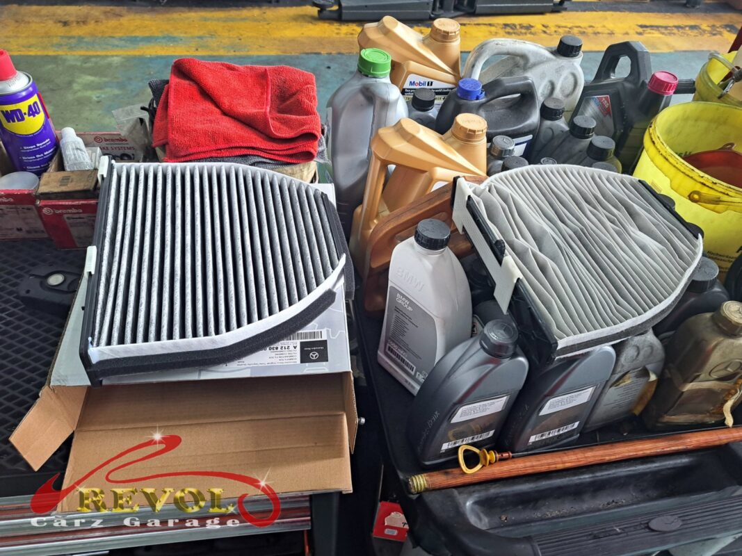 Fresh filters laid out at the service: a new cabin filter and the new engine air filter, with the oil ready behind.