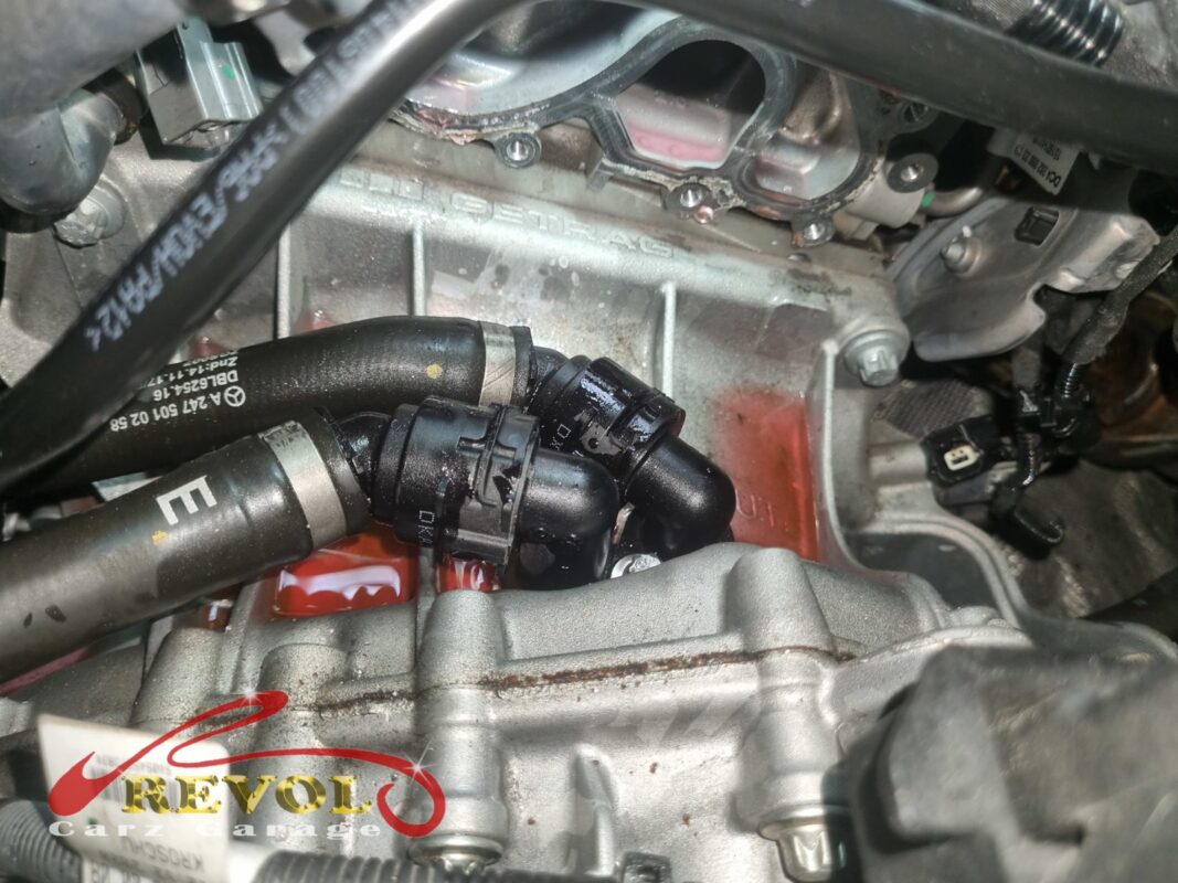 The thermostat housing on the engine, hoses connected, before it came off.