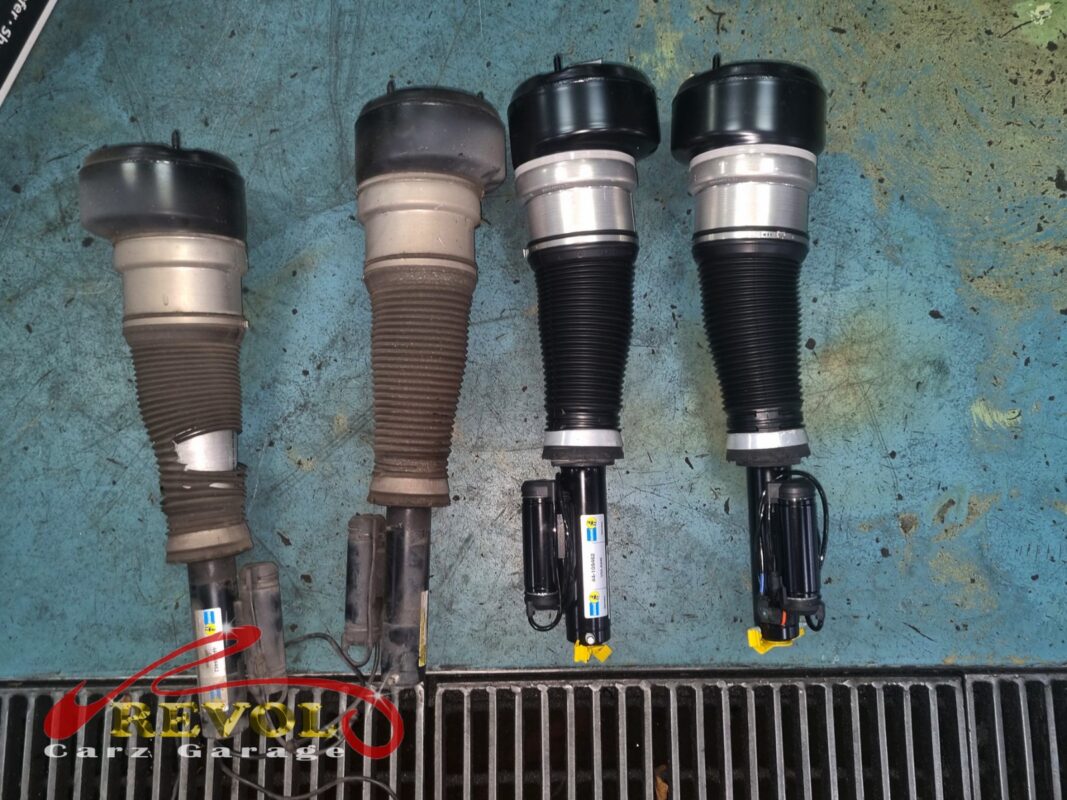 The old AIRMATIC air struts (left, bellows perished) beside the new Bilstein replacements (right).