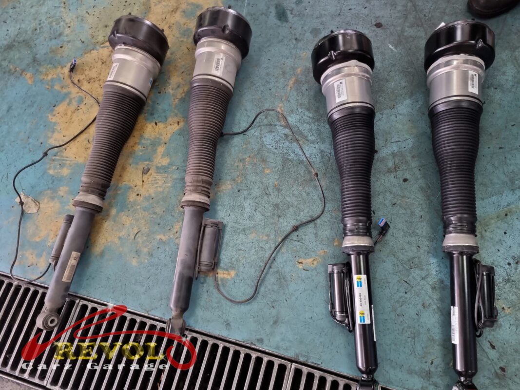 Old and new AIRMATIC struts side by side before the swap.