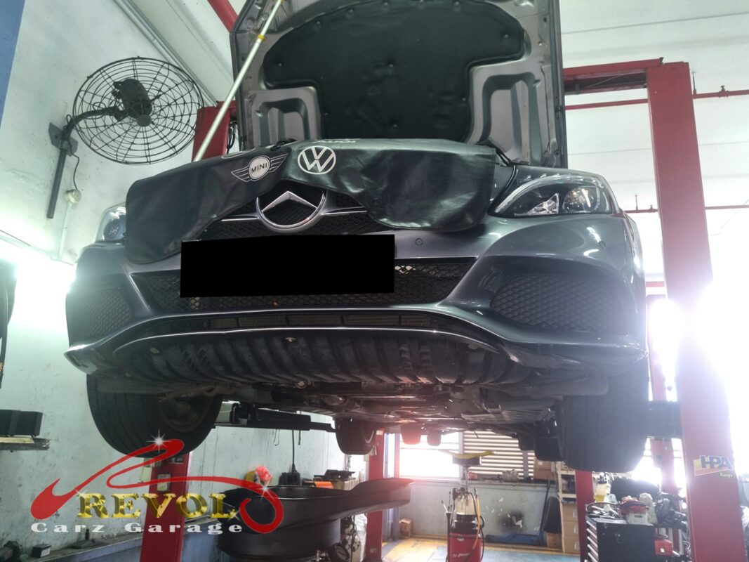 The C180 up on the two-post lift, fender cover on, in for the coolant leak.